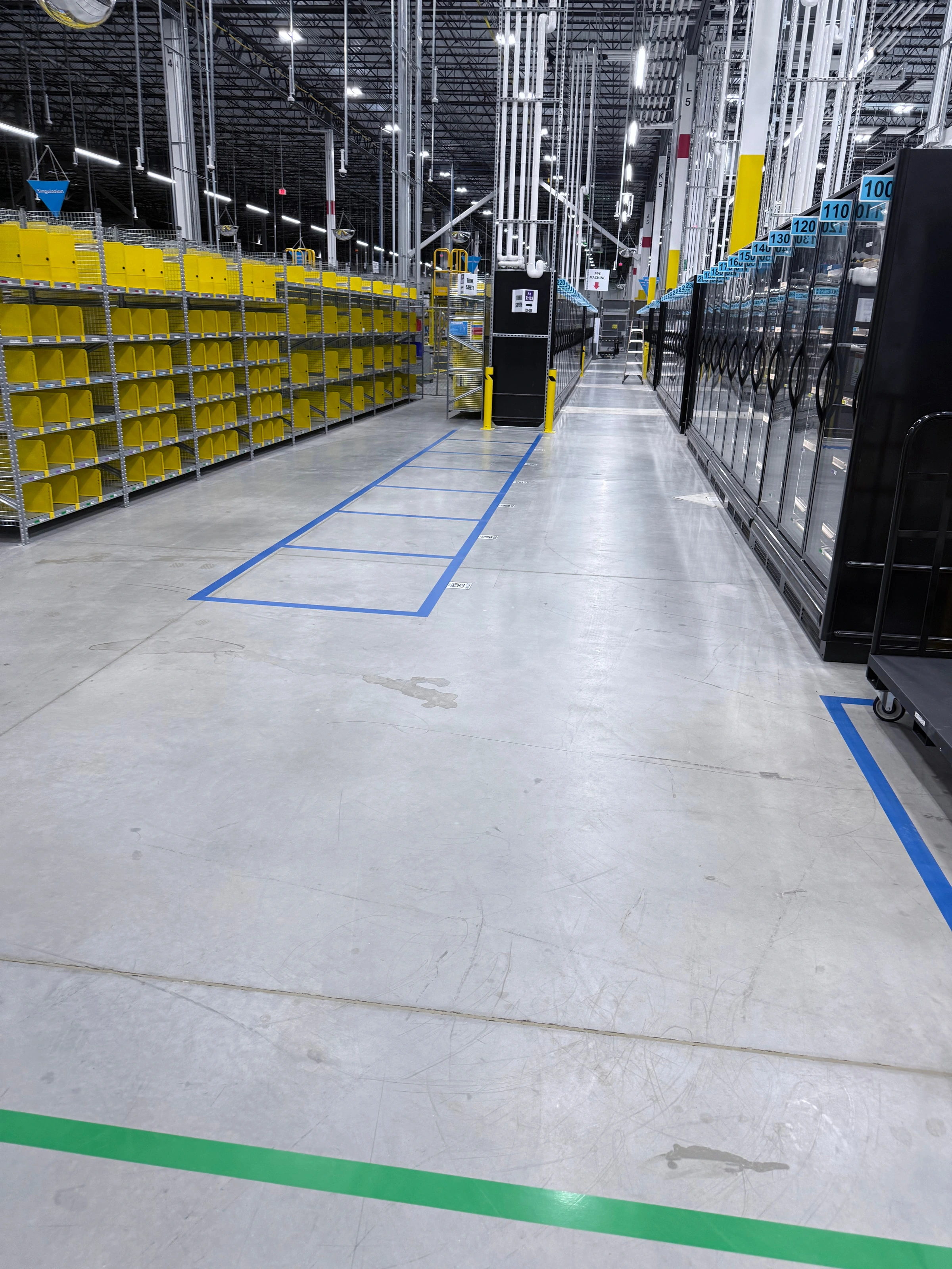 A clean, finished warehouse aisle with marked floor lanes