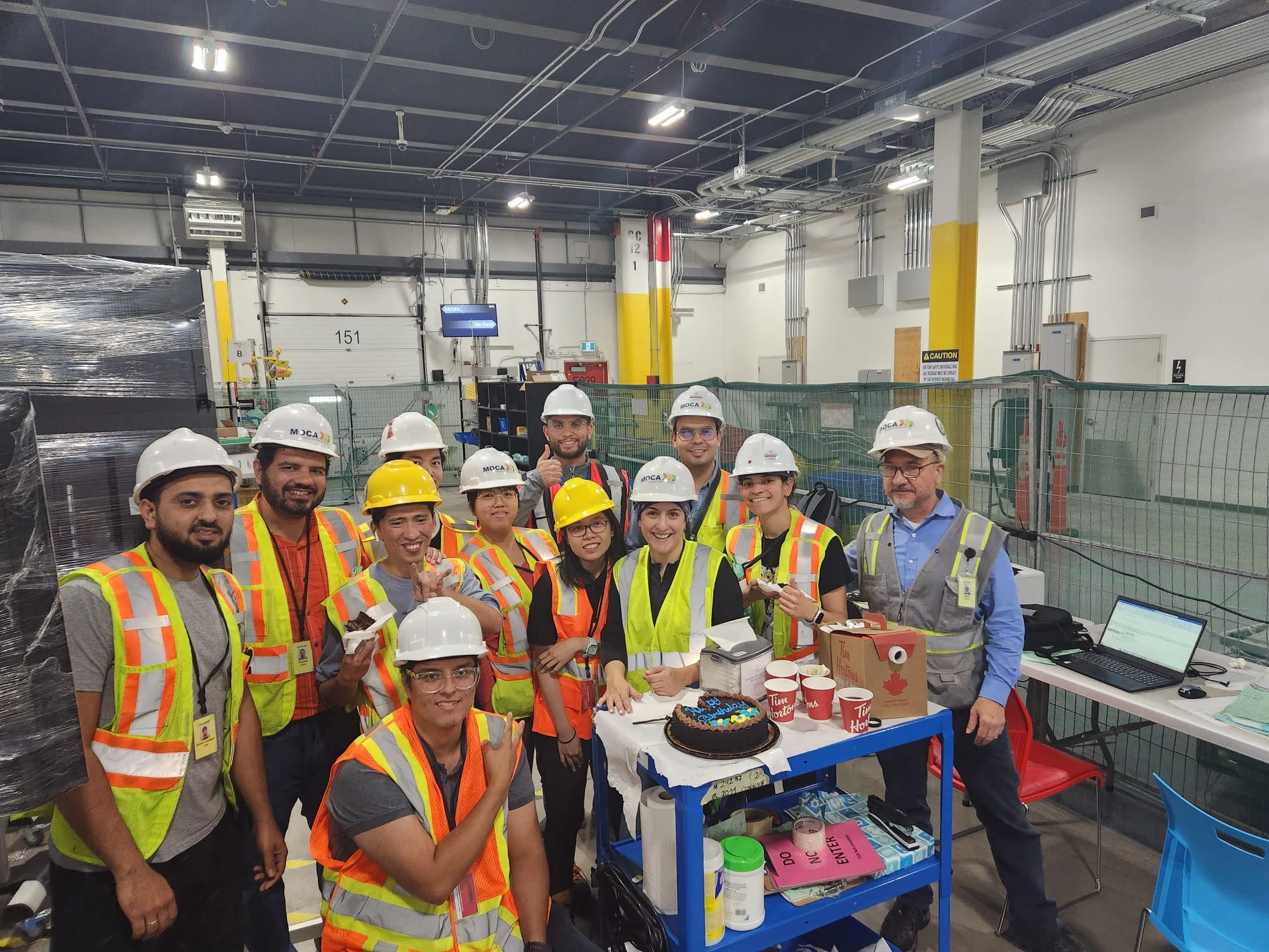 A MOCA field crew in hard hats and vests gathered on a customer site