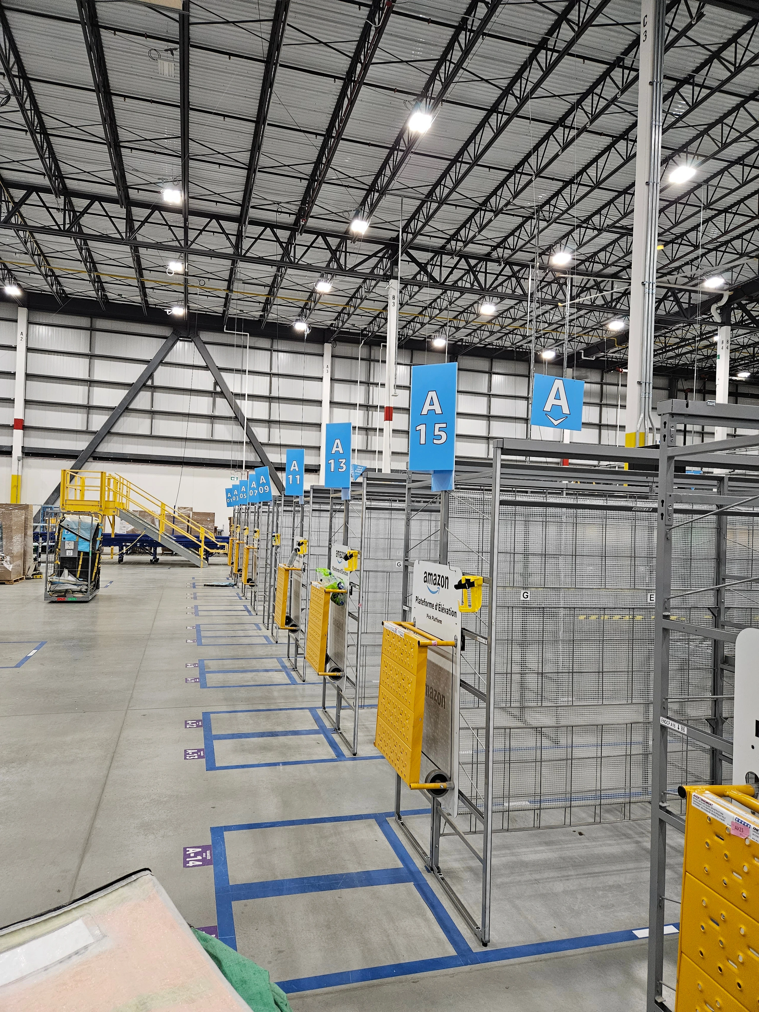 A finished station: aisle signs hung, cages installed and the floor marked, ready to run