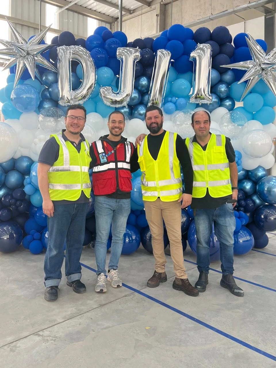 Four members of the MOCA team celebrating a site launch in front of a balloon arch